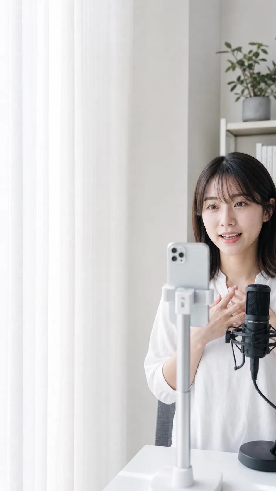 スマートフォンに向かってライブ配信をする女性